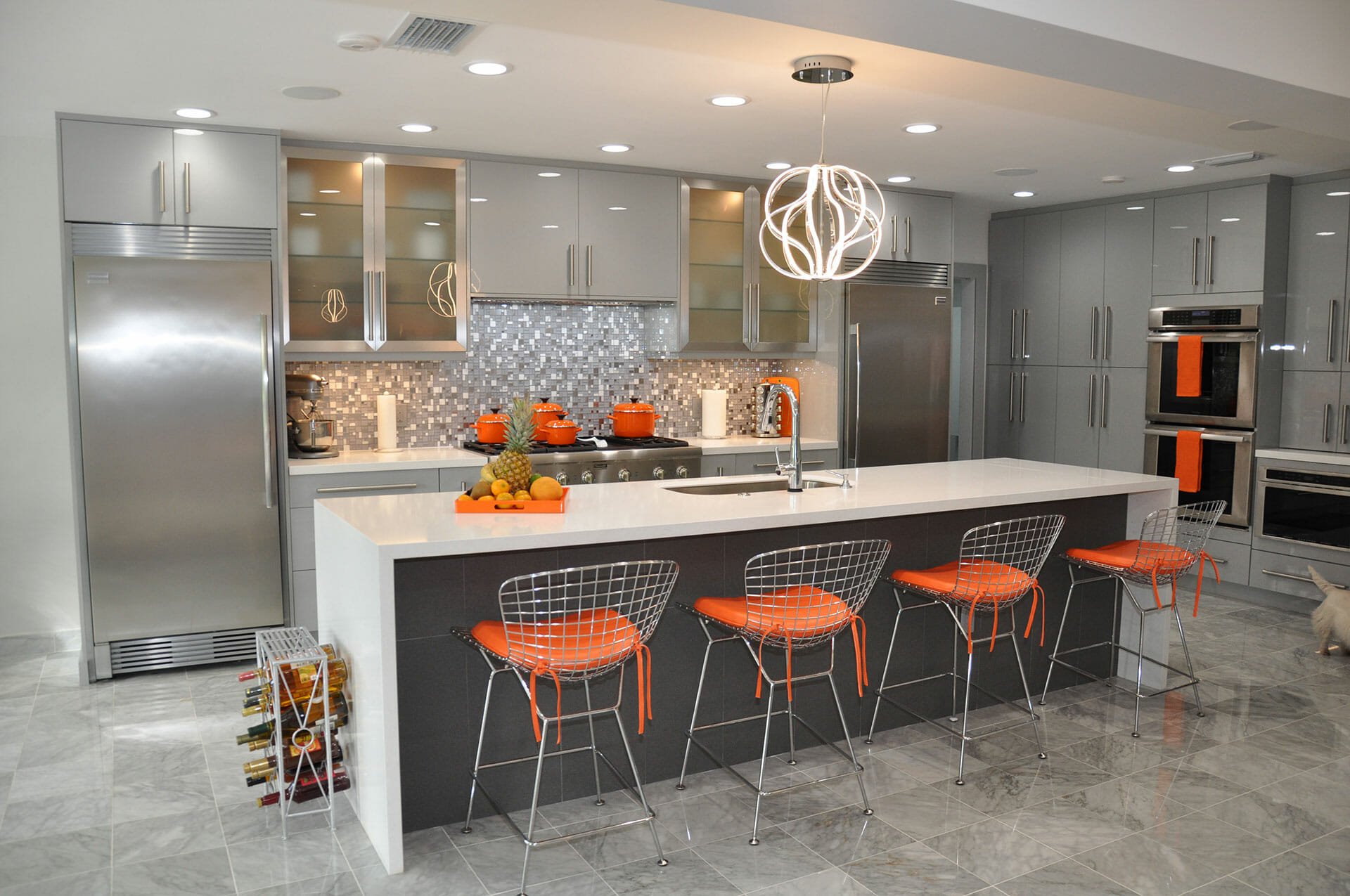 Contemporary gray kitchen cabinetry with a large white waterfall island and counter seating