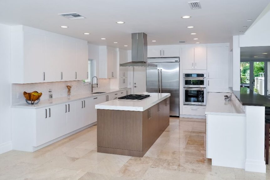 White kitchen with wood grain island and stainless island hood