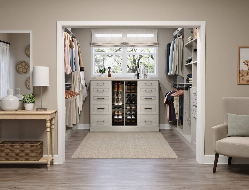 Organized walk-in closet with clothes and shoes.
