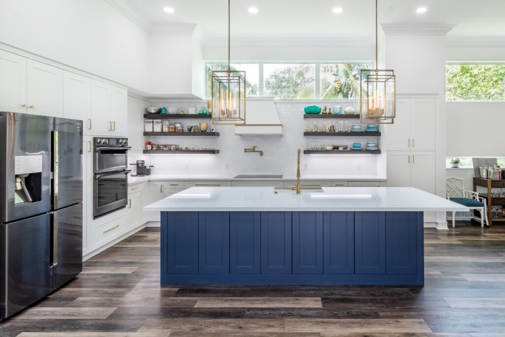 Modern kitchen with blue island and white cabinets.