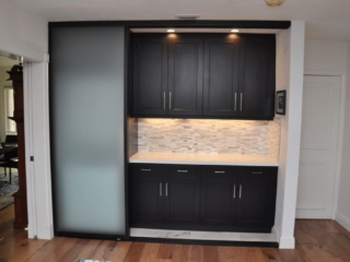 Modern black cabinets with tile backsplash and lighting