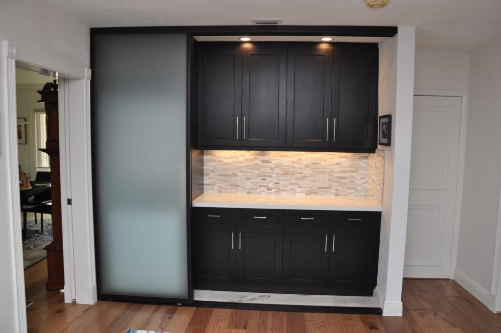 Modern black cabinets with tile backsplash and lighting