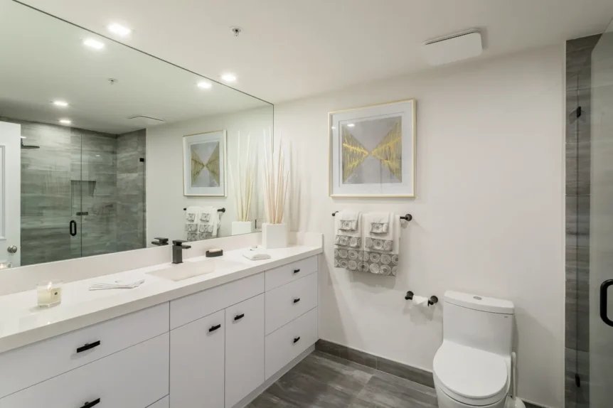 White double vanity with black fixtures and a glass-enclosed shower